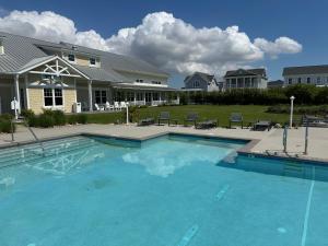 a large blue swimming pool in front of a house at Creekside - Custom Luxury in Bay Creek Resort! in Cape Charles