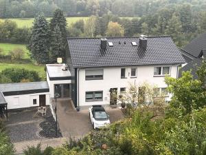 a white car parked in front of a house at Ferienhaus EifelOne in Heimbach
