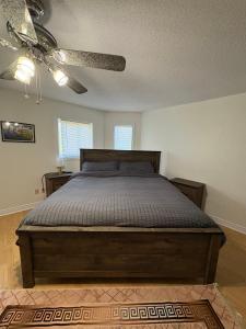 a bedroom with a bed and a ceiling fan at Comfy & Spacious 4BR Family Home with Free Parking, Laundry, BBQ! 10 Min Walk to Headwaters Hospital, 5 Min Drive to Mount Alverno Luxury Resorts, Ideal for Medical, Vacation or Work Stays! in Orangeville