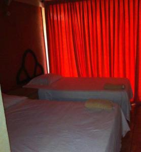 a red room with two beds and a red curtain at Hotel paso real in Coyolar