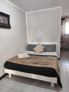 a bed in a bedroom with a white wall at stelle in Villa Rosa