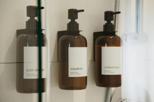 a group of three bottles of soap on a wall at Private luxury Room -B, King bed, Full Ensuite, Free Shuttle to ski hill and Resort in Mont-Tremblant +7 photos