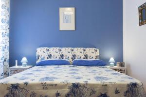 a blue bedroom with a bed with a blue wall at Villa Soliva - Mare e Panorama Unico in Mondello