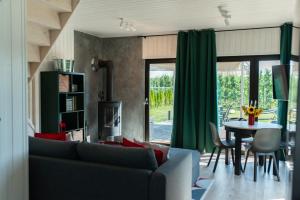 a living room with a couch and a table at Uroczysko nad Pilicą Sauna & Balia in Pilica