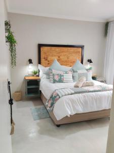 a bedroom with a large bed with a wooden headboard at Edjami River View in Marloth Park