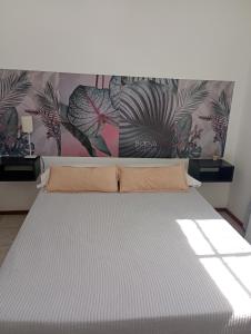 a bed in a room with a wall with plants at Dúplex 2 habitaciones in San Nicolás de los Arroyos