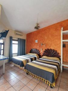 twee bedden in een kamer met oranje muren bij Hotel Hortencia in Puerto Vallarta +42 foto's