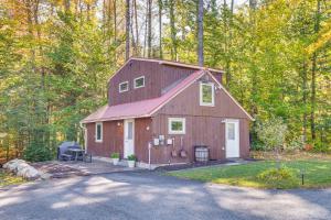 a red barn in the middle of a forest at Hiking and Snowmobile Trails On-Site Alton Retreat! in Alton Bay