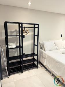 een slaapkamer met een zwarte plank naast een bed bij Summer Flat 208 in Ilha da Restinga