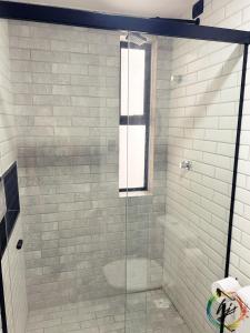 een douche met een glazen deur in een badkamer bij Summer Flat 208 in Ilha da Restinga