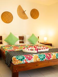 a bed with a colorful blanket on top of it at Kite Oasis Parajuru Casa Ilha in Parajuru
