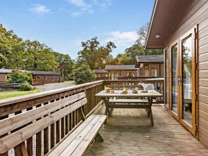 a wooden deck with a table and benches on it at 3 Bed in Okehampton 95636 in Okehampton