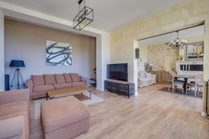 a living room with a couch and a table at Gîte des Coteaux - Family home with pool in Saint-Aignan