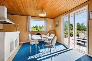 a dining room with a white table and chairs at FAN070-Fano-Nybyvej-58-B in Fanø +23 photos
