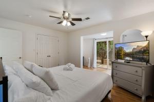 a white bedroom with a large bed and a ceiling fan at Steps From Balloon Fiesta Park Outdoor Retreat in Albuquerque +69 photos
