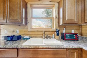 a kitchen counter with a sink and a window at Brook Haven Cabin in Jeffersonville +33 photos