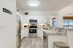 a kitchen with white cabinets and a stove top oven at Eagle Springs East 314: Maximus Suite in Solitude