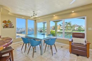 Un comedor con mesa y sillas y ventanas. en Bay Breeze, en Lido Isle