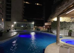 a large blue swimming pool in a building at night at Sea View 10 Boca Towers in Boca del Río +5 photos