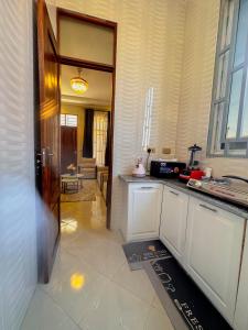 a kitchen with white cabinets and a door to a room at Cool Stay Apartments Dodoma in Dodoma