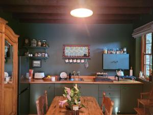 a kitchen with a wooden table and a counter top at Stone Cottage With Sea Views in Wilderness