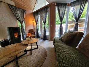 a living room with a table and a couch at Secret Wellness Droombos in Holten