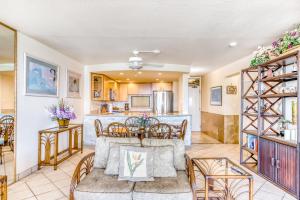 Una sala de estar con mesa y sillas y una cocina. en Paki Maui 122, en Honokowai