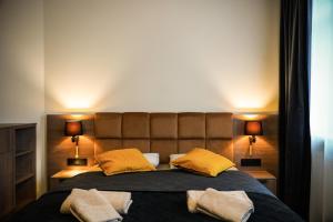 a bedroom with a large bed with two lamps at Aparthotel CENTRUM Wrocławska 13 in Bytom