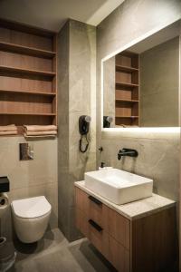 a bathroom with a sink and a toilet and a mirror at Aparthotel CENTRUM Wrocławska 13 in Bytom +16 photos