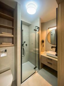 a bathroom with a shower and a toilet and a sink at Aparthotel CENTRUM Wrocławska 13 in Bytom