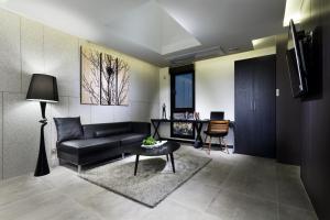 Hotel Sienna في باجو: غرفة معيشة مع أريكة وطاولة