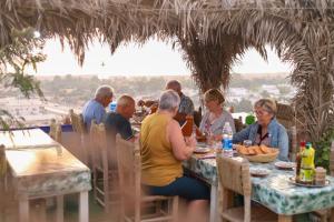 a group of people sitting at a table eating at Blue Rina Hostel in Agadir