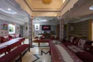 a living room with red couches and a tv at Blue Rina Hostel in Agadir