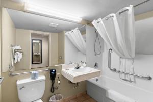 a bathroom with a sink and a toilet and a tub at Country Inn & Suites by Radisson, Saskatoon, SK in Saskatoon +36 photos