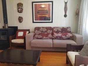 a living room with a couch and a table at CASA FULL CENTRAL, 130m quadr, 9 Pessoas, Wi-Fi, 3 Qtos, Churrasqueira Interna, Cozinha-Sala Integrados, 2 Banheiros, Varanda, Jardim, Garagem Coberta 1 Carro, Estac Inter 3 Carros, Lareira de Alta Performance, Fogão de Ferro, Área nos Fundos in Cambará