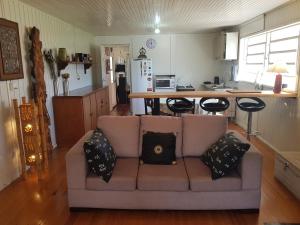 a living room with a couch and a kitchen at CASA FULL CENTRAL, 130m quadr, 9 Pessoas, Wi-Fi, 3 Qtos, Churrasqueira Interna, Cozinha-Sala Integrados, 2 Banheiros, Varanda, Jardim, Garagem Coberta 1 Carro, Estac Inter 3 Carros, Lareira de Alta Performance, Fogão de Ferro, Área nos Fundos in Cambará
