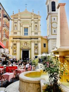 a building with a fountain and people sitting at tables at Rossetti in Nice