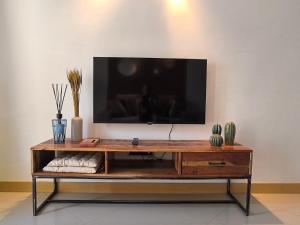 サンタ・マリアにあるBoho Chic Relax City Center Beachの木製のエンターテイメントセンターの上に座ったテレビ