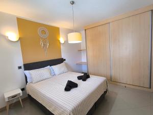 サンタ・マリアにあるBoho Chic Relax City Center Beachのベッドルーム1室(黒い靴2本付きのベッド1台付)