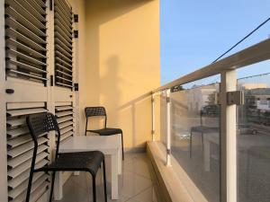 サンタ・マリアにあるBoho Chic Relax City Center Beachのバルコニー(椅子2脚、テーブル付)、窓が備わります。