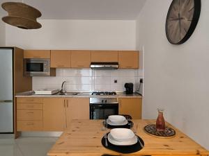 サンタ・マリアにあるBoho Chic Relax City Center Beachのキッチン(木製テーブル、皿付)