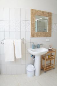 Un baño blanco con lavabo y espejo. en Ilidia Guest House, en Sal Rei 68 fotos más