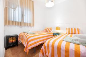 two beds in a room with a fire place at Apartamentos - PinkSparrow - in Granada