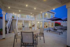 a patio with a table and chairs and a house at Beacons in Encinitas