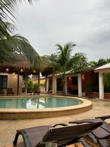 a swimming pool in a resort with chairs and palm trees at CASA VICTORIA in Chichén-Itzá +36 photos