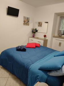a bedroom with a blue bed with red pillows at La casa dei ricordi in Acqualagna +36 photos