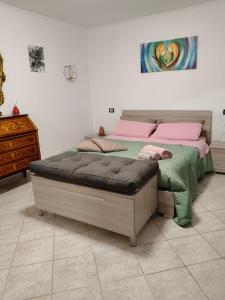 a bedroom with a large bed with pink and green sheets at La casa dei ricordi in Acqualagna