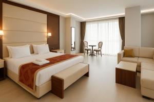 a bedroom with a bed and a couch and a table at Cevaher Hotel & Suıtes in Sancak +53 photos