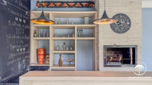 Ein Zimmer mit einem Regal mit Vasen und einem Kamin in der Unterkunft Casa com piscina 3 suítes a 15 min Centro Gramado in Gramado