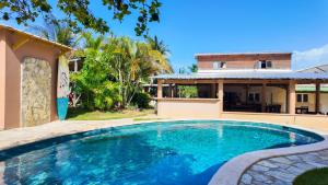 a swimming pool in front of a house at Gipsy Ranch Rooms in Cabarete